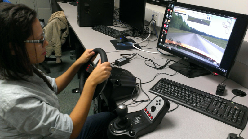A student using a driving simulator with the G27 racing wheel